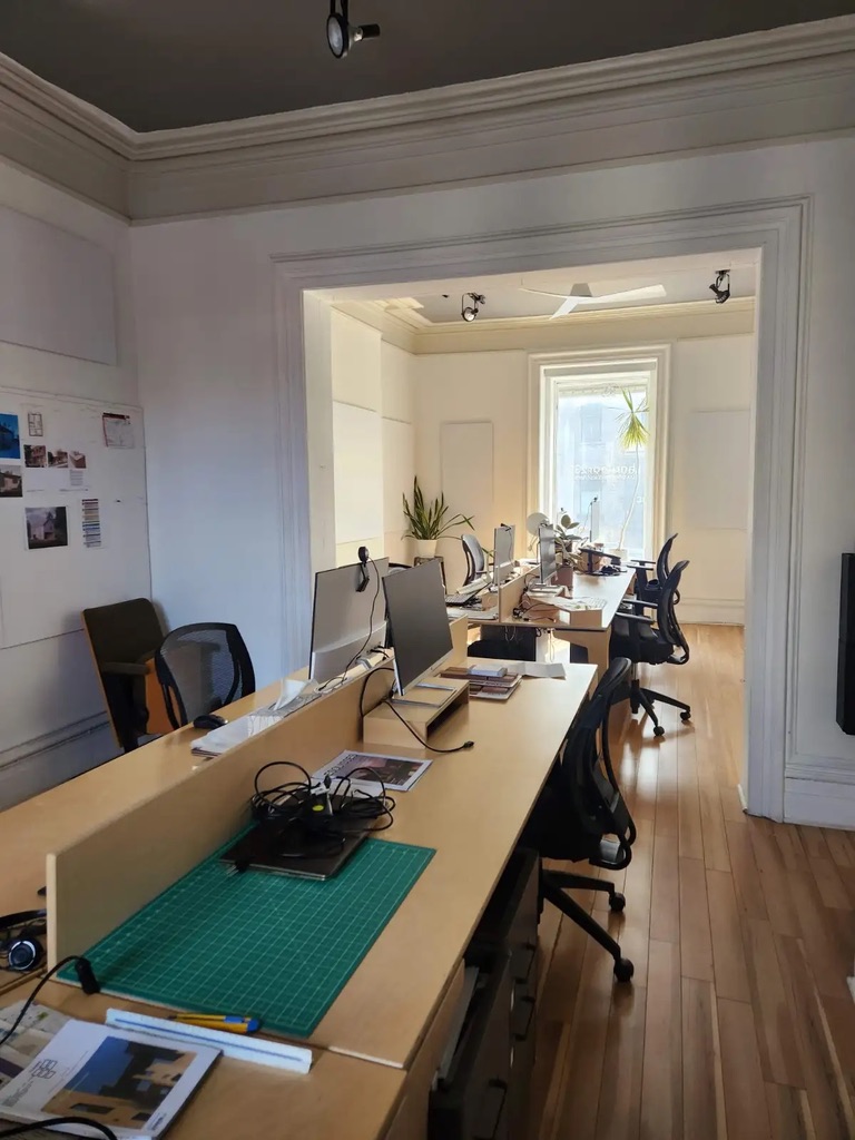 Ω Labs workspace, shared desks with monitors and natural light